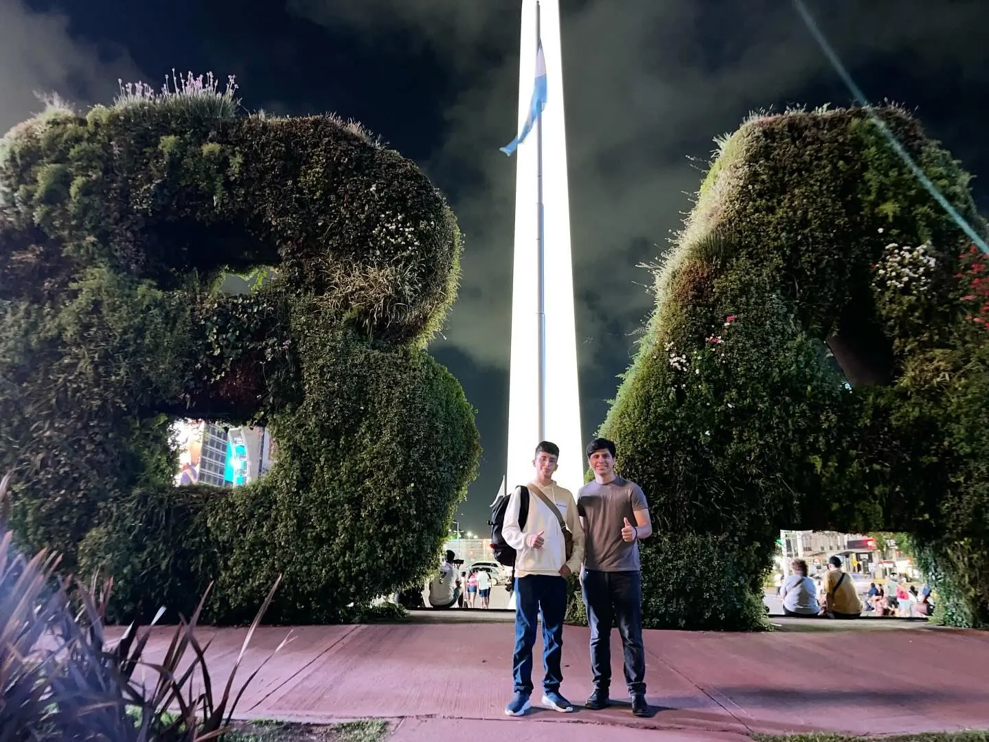 Un estudiante y su asesor frente al Obelisco de Buenos Aires, de noche