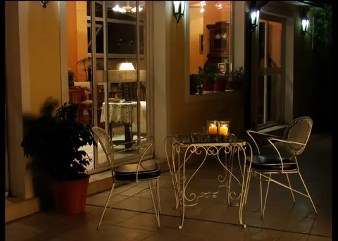 Patio con mesa y sillas, iluminado de noche