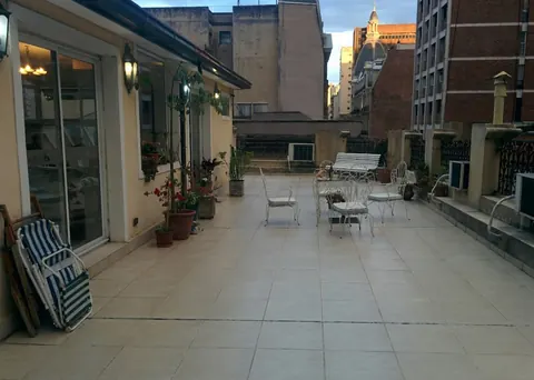 Terraza amplia de la residencia, con sillas y plantas