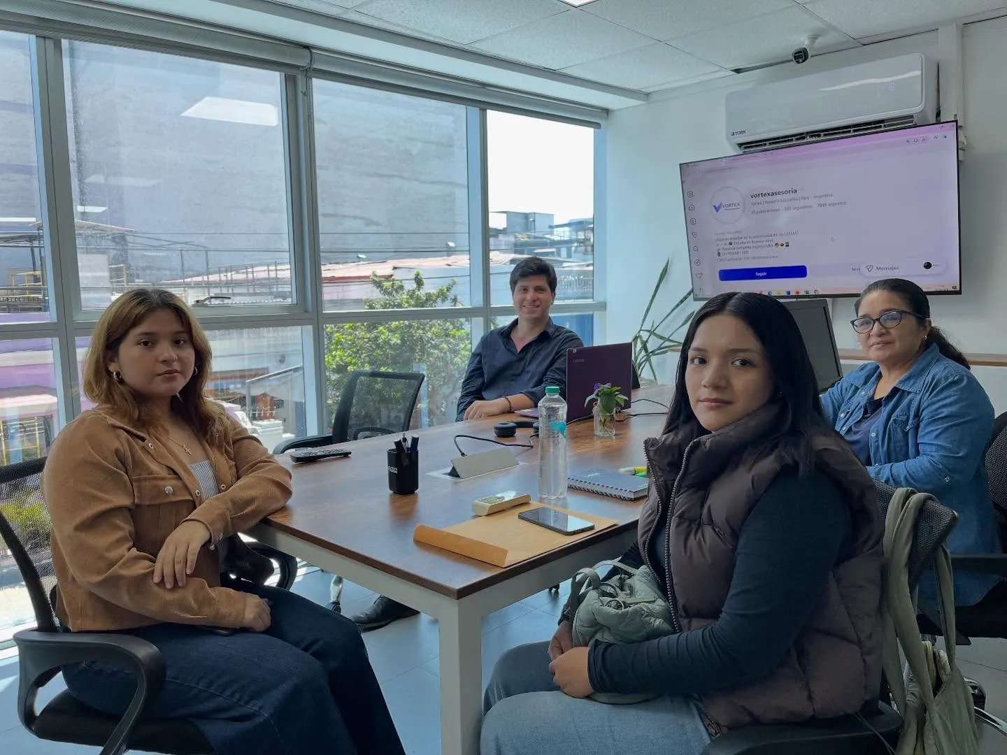 Reunión de orientación en la oficina de Miraflores: el asesor con dos estudiantes y una mamá alrededor de la mesa